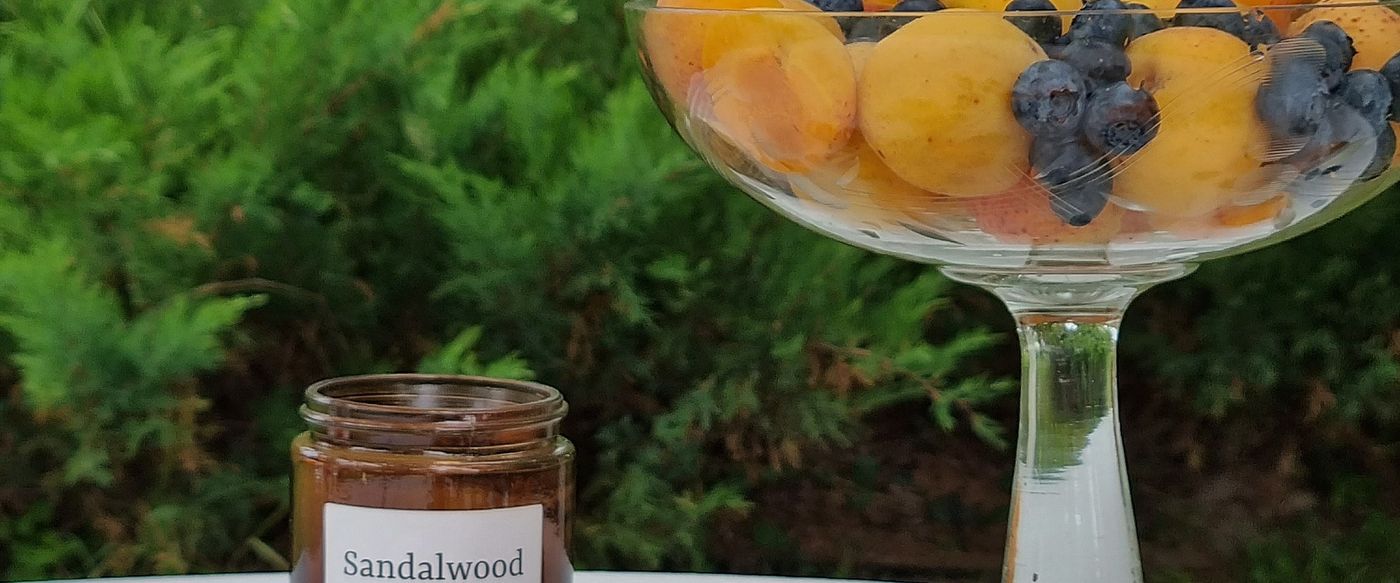 Apricots, blueberries and candles on a garden table, a fruity setting for best wax melts