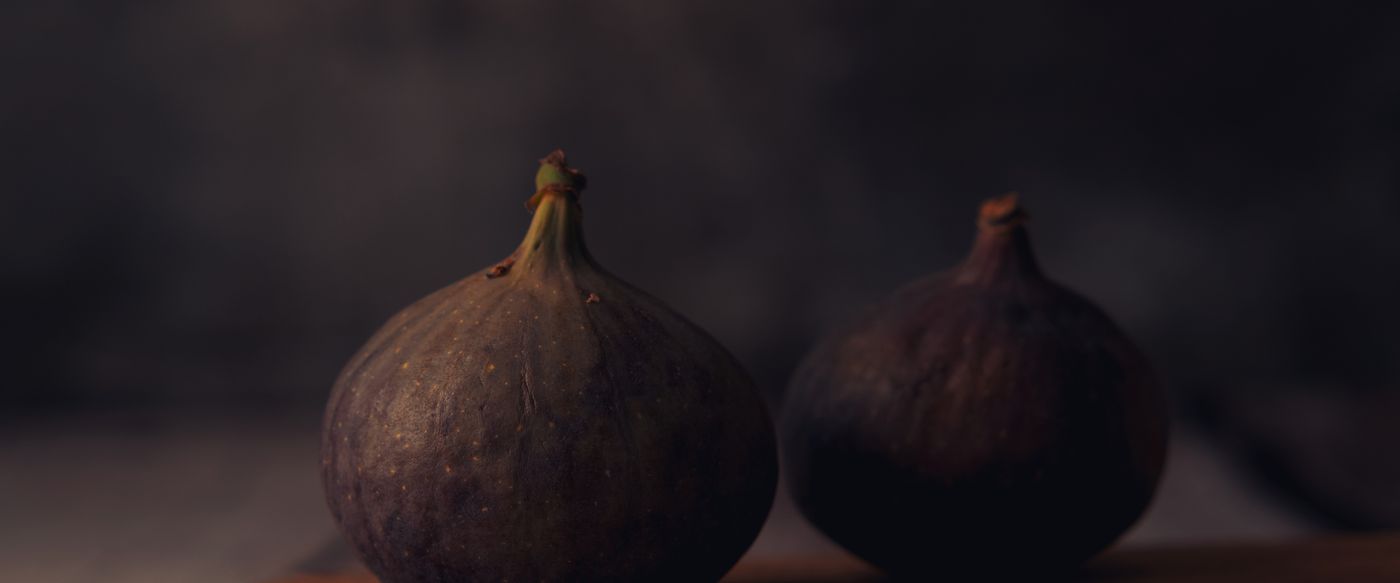 Two fresh figs on a rustic wooden board, a scent idea for fruity candles