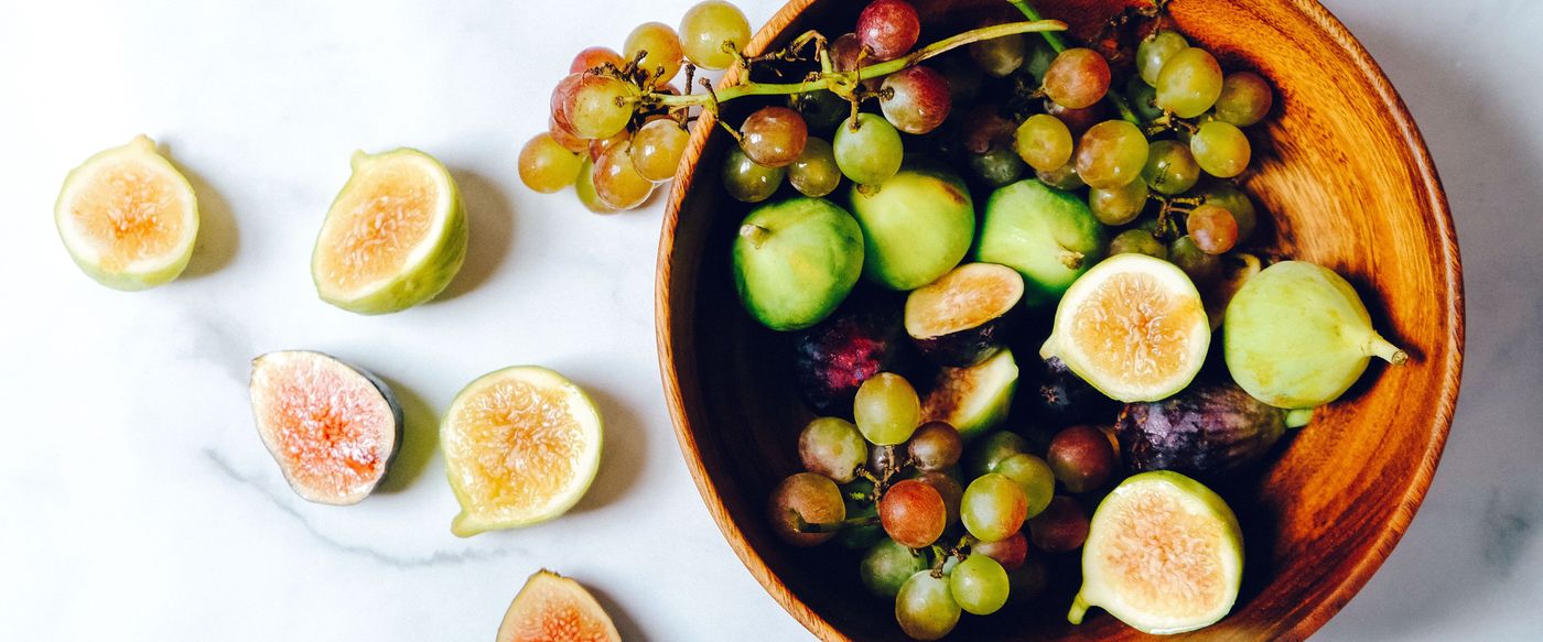 Bowl of green grapes and figs on marble, a fruity scent that recalls summer