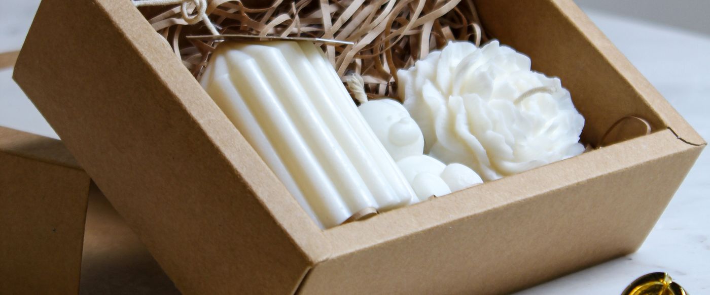 Buy scented candles in a gift box, white candles with a gold snuffer on marble