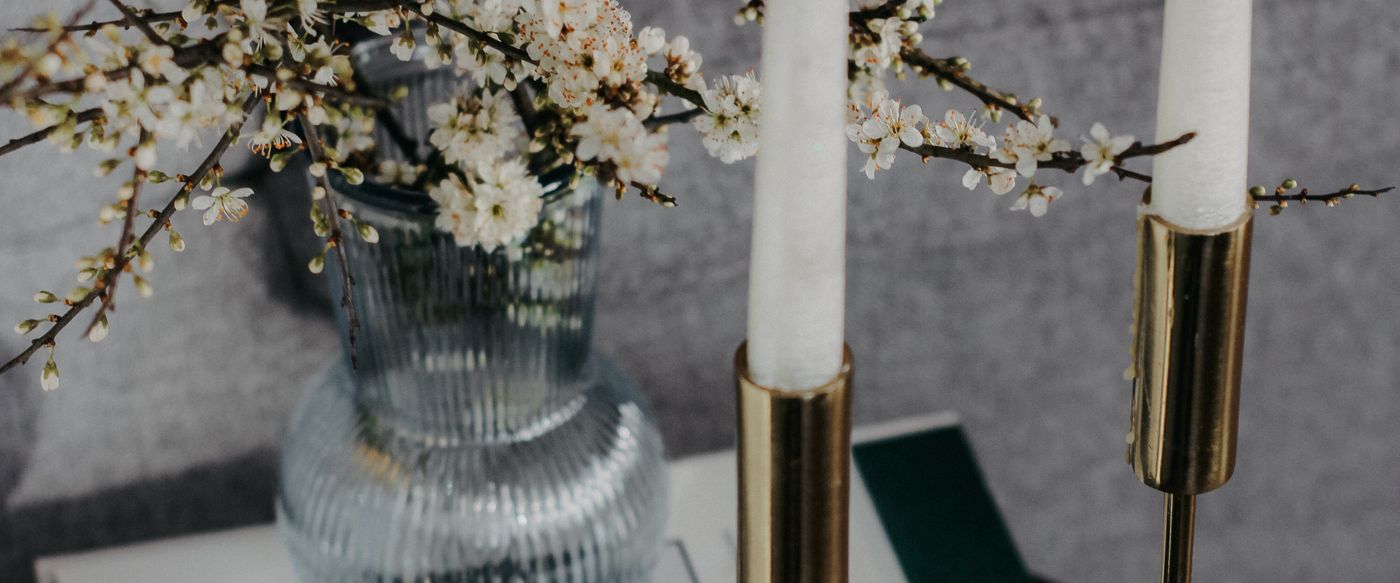 Lit candles and spring blossoms on a coffee table, a spot for three wick candles
