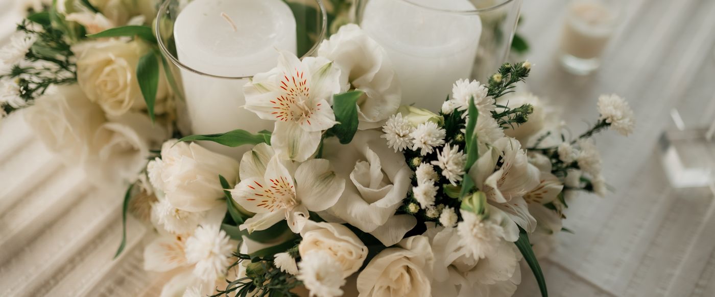 White flowers and candles arranged on a table, a soft floral look for perfumed candles online