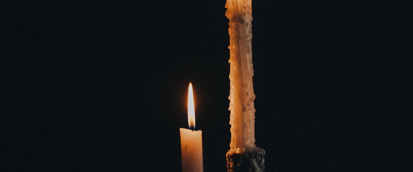 Aromatherapy candle set shown as two lit candles glowing warmly against a dark background