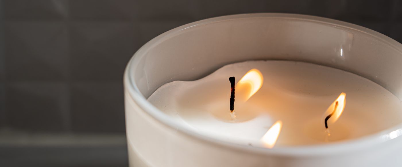 Scented candles Australia: a lit candle in a jar glowing softly on a table