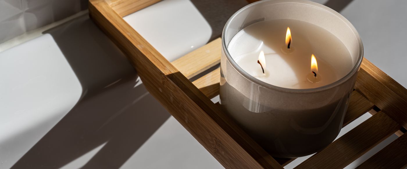 Lit fragrant candle on a wooden tray adding warmth to a calm room