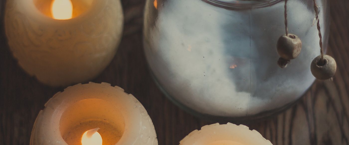 Candles burning on a rustic wooden table, a cosy setup for safe scented candles at home