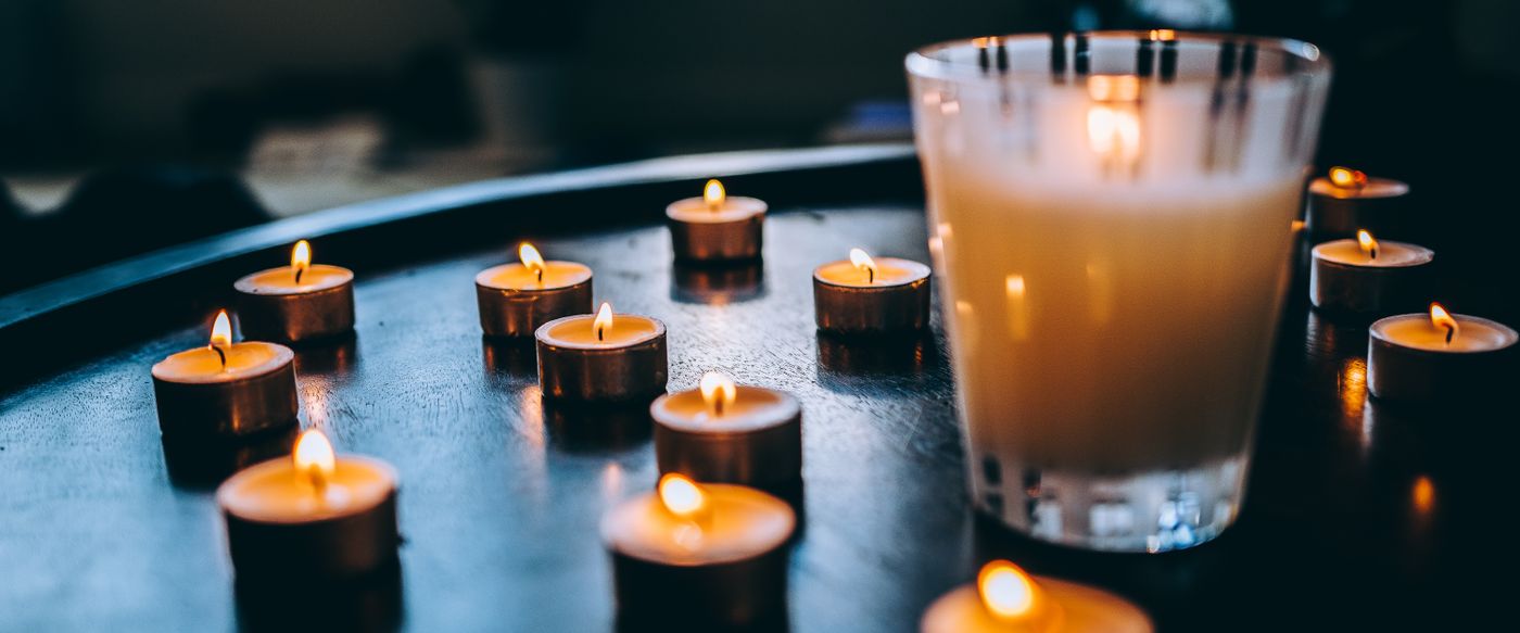 Single lit candle on a wooden table, the candle perfume every nose smells differently