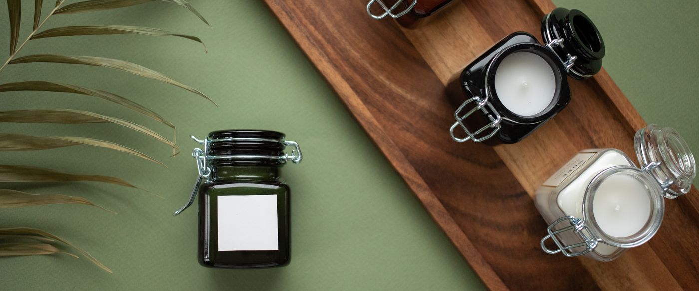 Musk candle jars glowing softly on a wooden tray at home