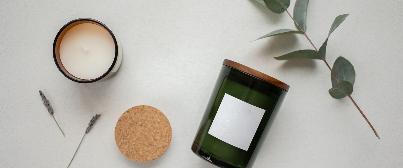 Top view of candles in green glass jars with leaves, a simple look for eco friendly scented candles