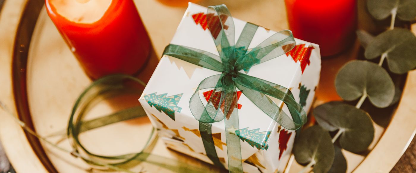 Wrapped Christmas scented candles gift on a tray with candles and eucalyptus