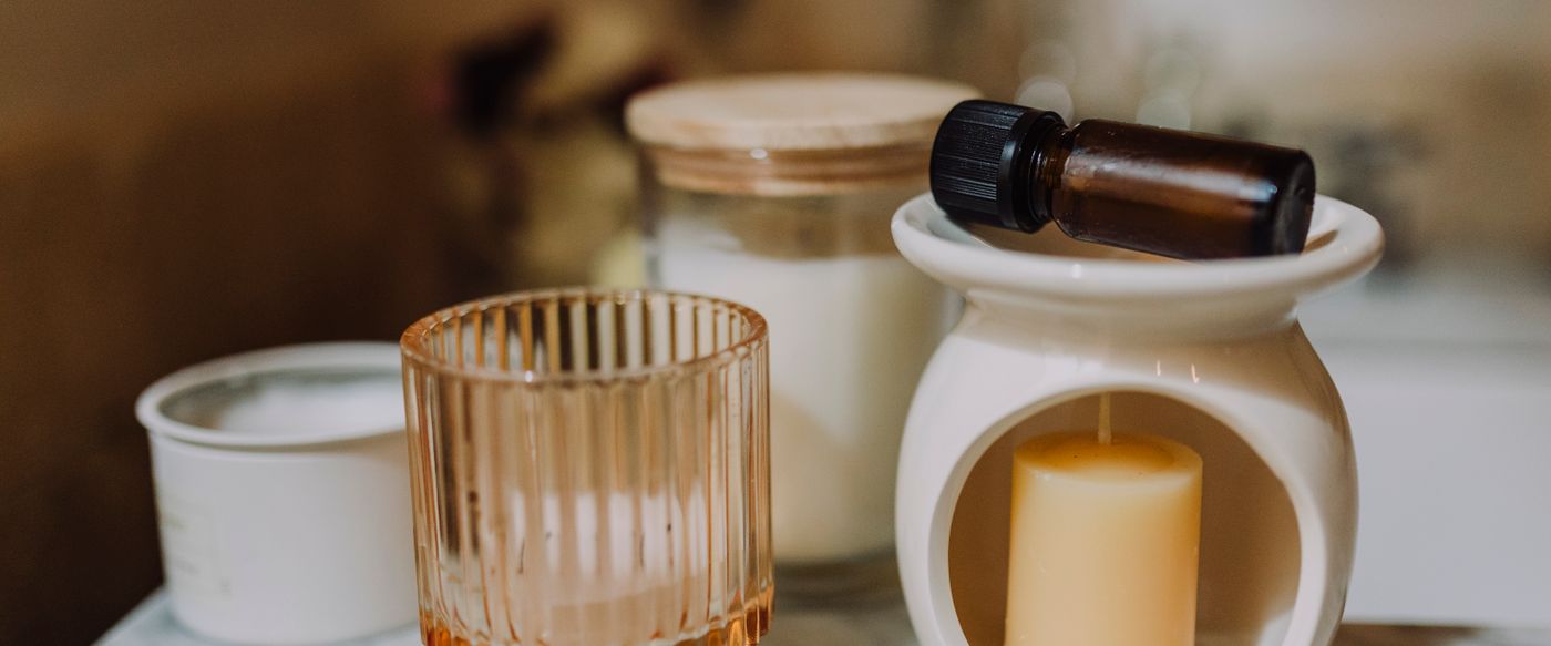 Candles in glass jars with an essential oil bottle on marble, for aromatherapy candles Australia