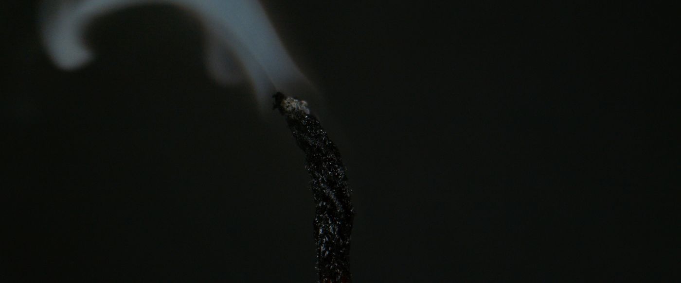 Snuffed candle wick giving off a thin line of smoke, a close-up for candle wick candles
