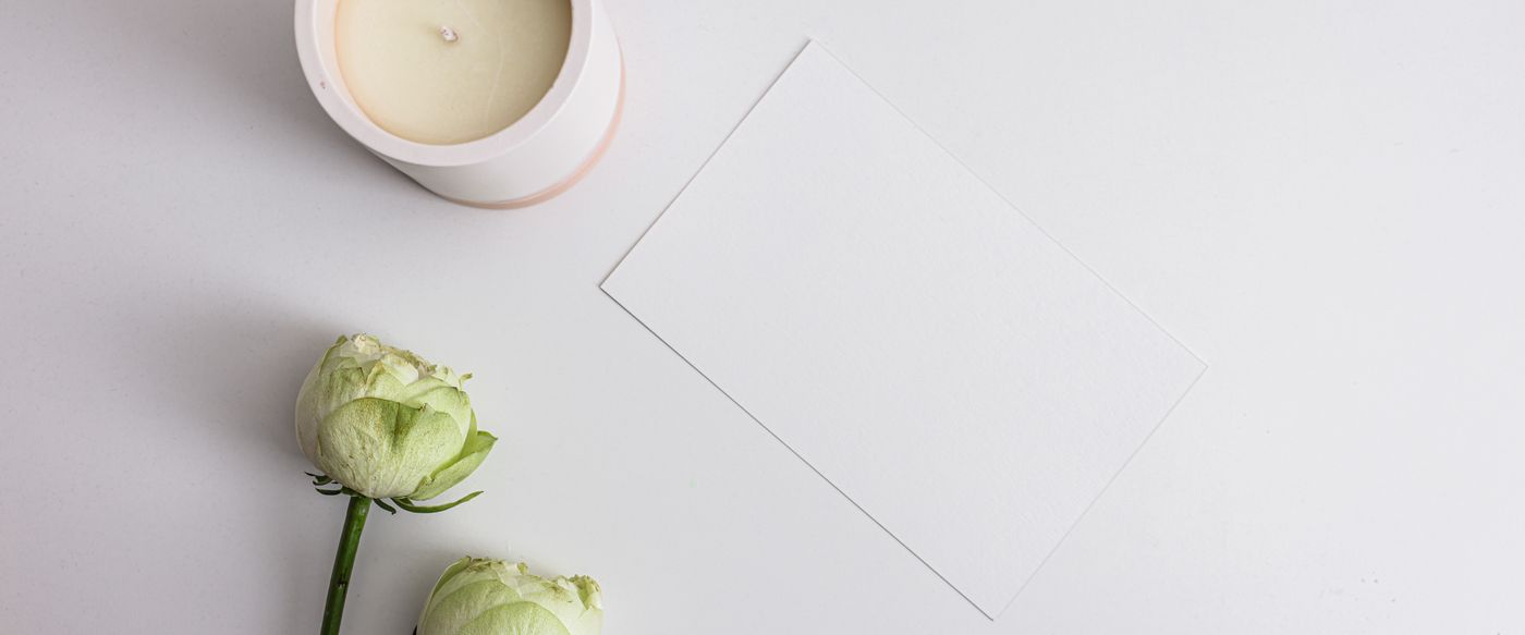 Best smelling candles styled with white flowers, a clean spring flat lay.