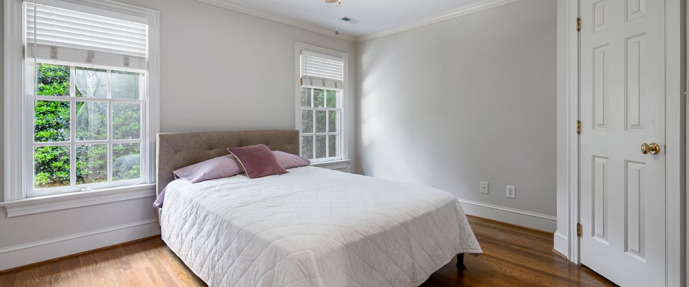 Bright bedroom with white bedding and open windows, a fresh space for stick scents